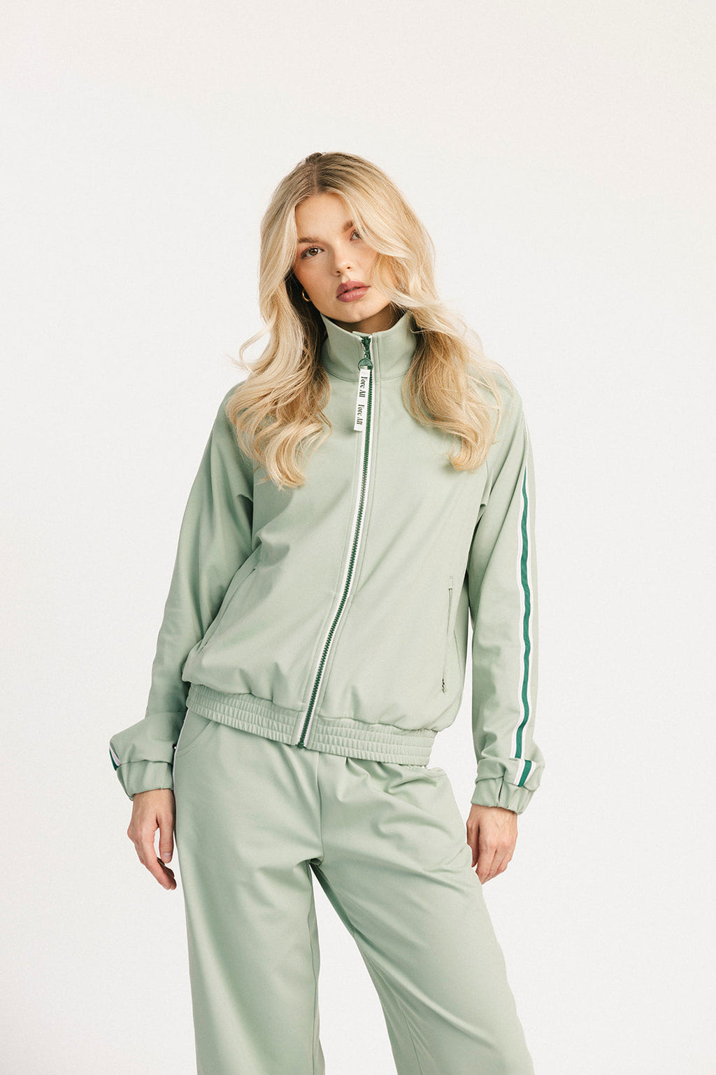 Woman wearing a light green tracksuit on a white background