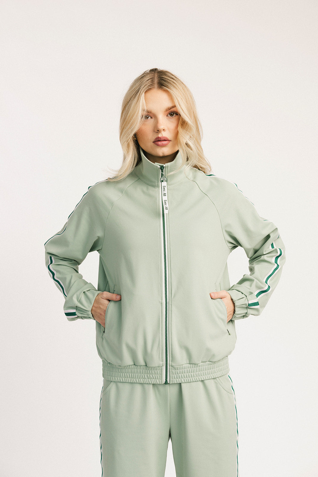 Woman wearing a light green tracksuit on a white background