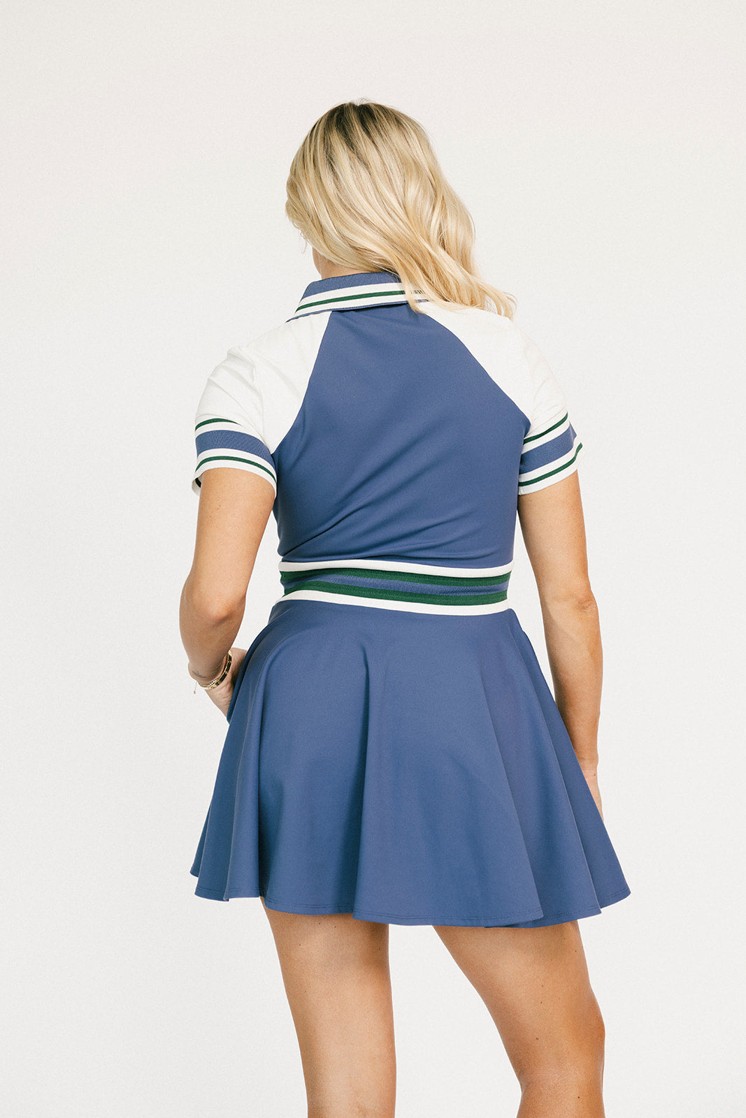 Woman wearing a blue and white dress with striped collar on a white background