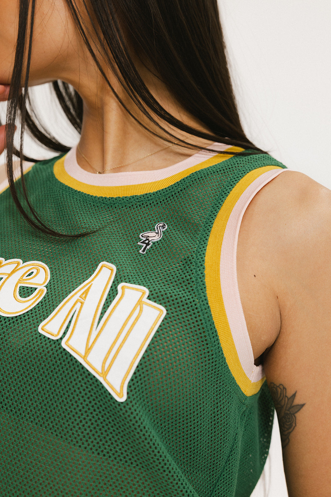 A female model wearing a green sleeveless tank top with 'Fore All' text and a logo on the chest, ribbed armholes, and a round neckline.