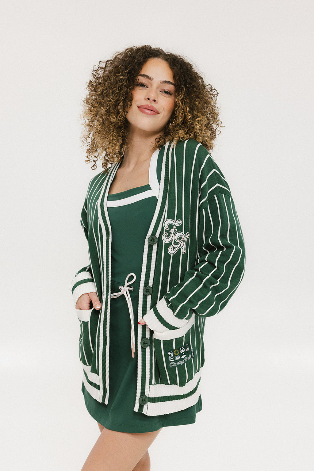 Person wearing a green and white striped cardigan with 'Chasing Balls' text.
