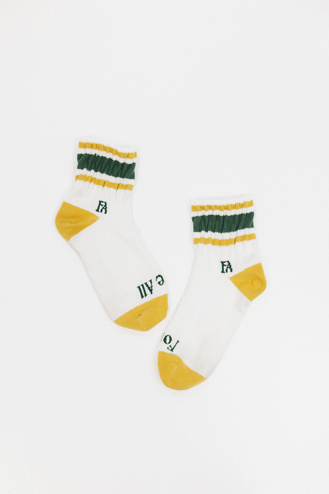 A pair of retro ankle socks with stripes and a logo in mustard and green colors.