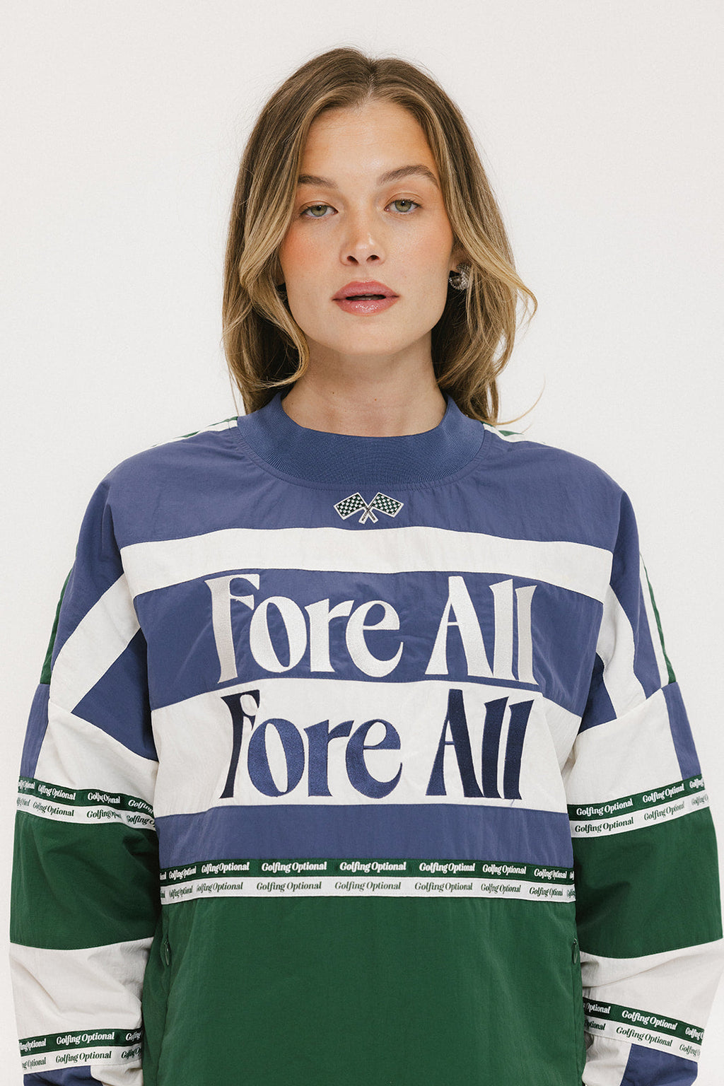 A woman wearing an indigo and green long-sleeved racing shirt with colorblocking and text embroidery.