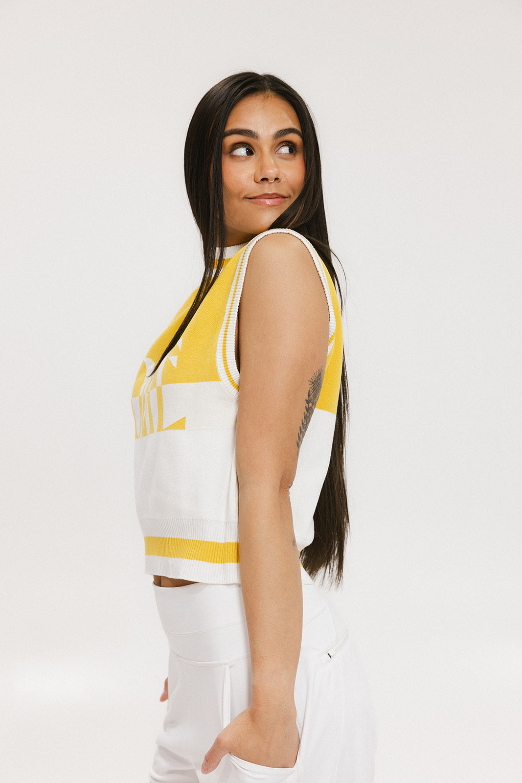 A sleeveless mock-neck sweater with intarsia knit design, featuring horizontal yellow and white stripes and the word 'FORE' printed across the chest.