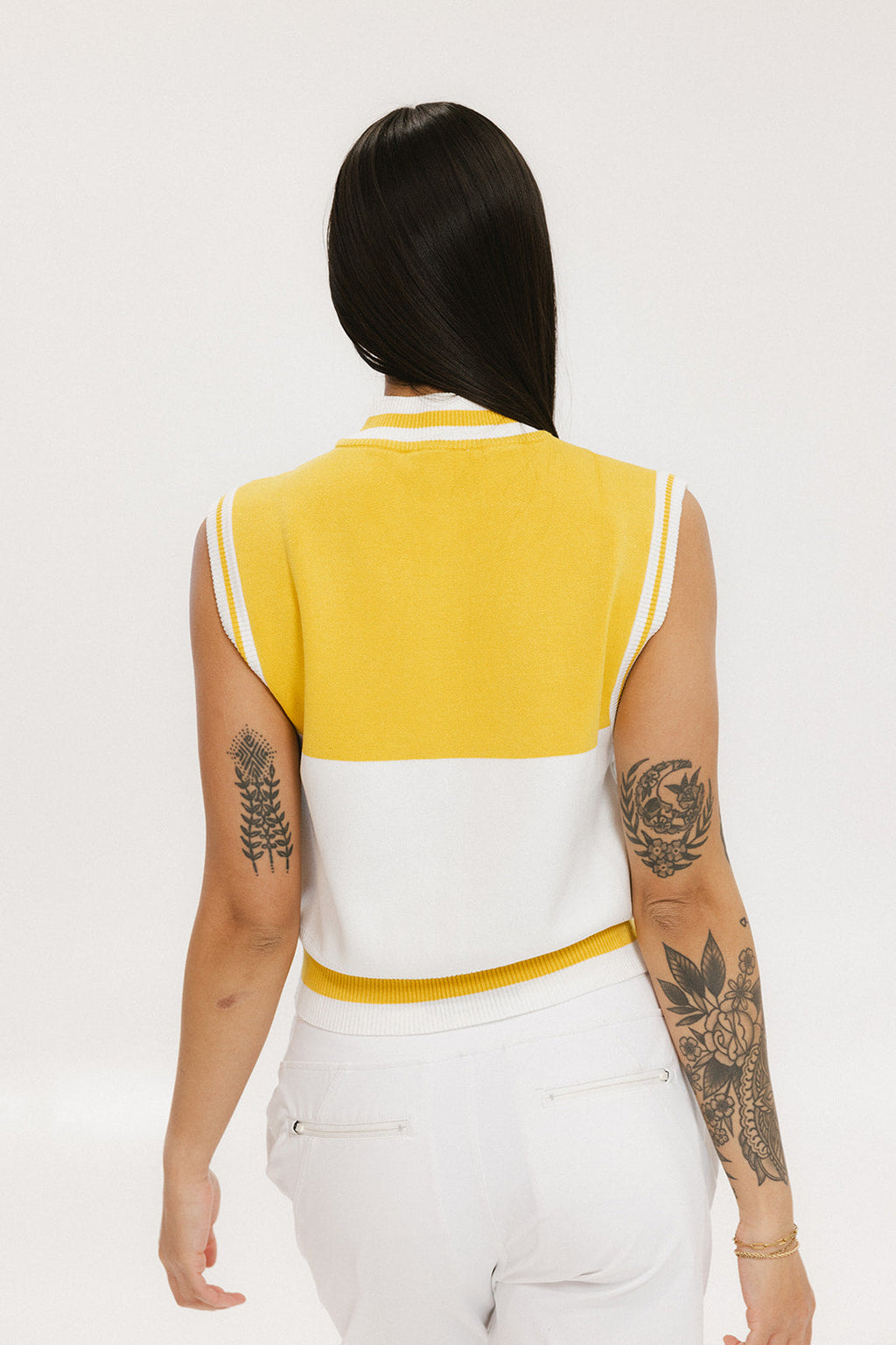 A sleeveless mock-neck sweater with intarsia knit design, featuring horizontal yellow and white stripes and the word 'FORE' printed across the chest.