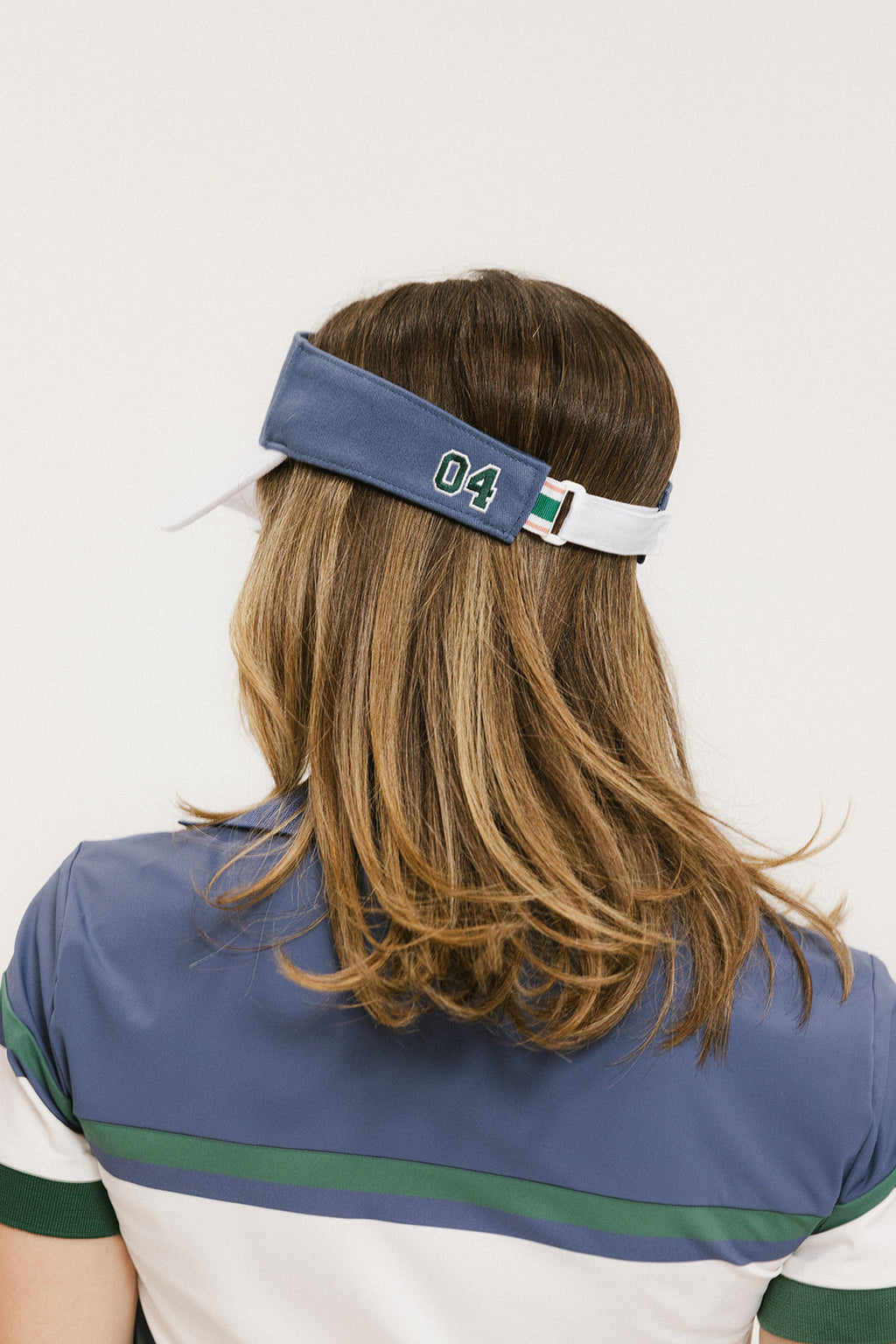 A model wearing a visor with 'FORE' written in bold letters on the front and '04' on the back, against a white background.