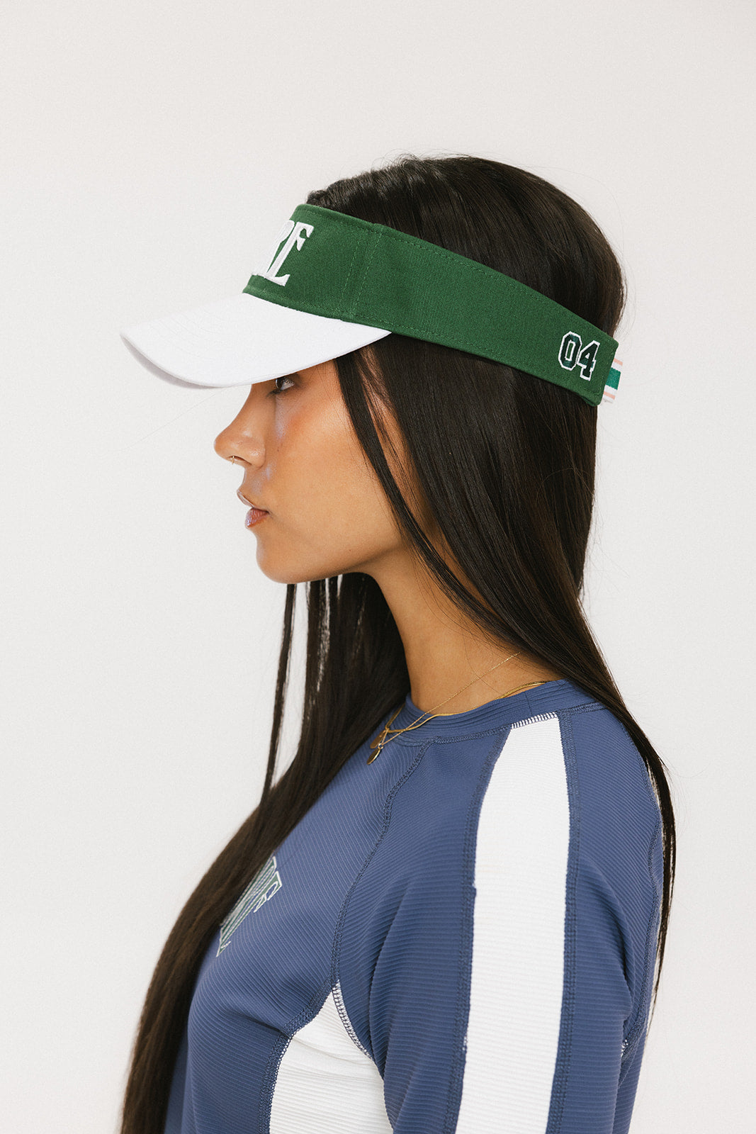 A model wearing a green and white visor with the text 'FORE' across the front and '04' on the back.