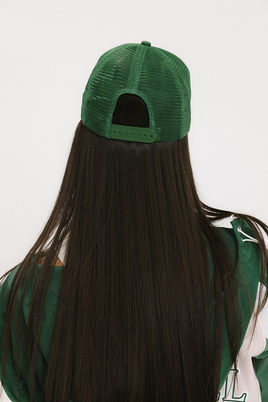 A model wearing a trucker hat with 'Double Bogeys Are Hot' text embroidered on the front, featuring a white mesh back and green visor.