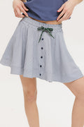 A seersucker skirt with subtle stripes, featuring a flat drawstring, faux buttons down the front, and side seam pockets.