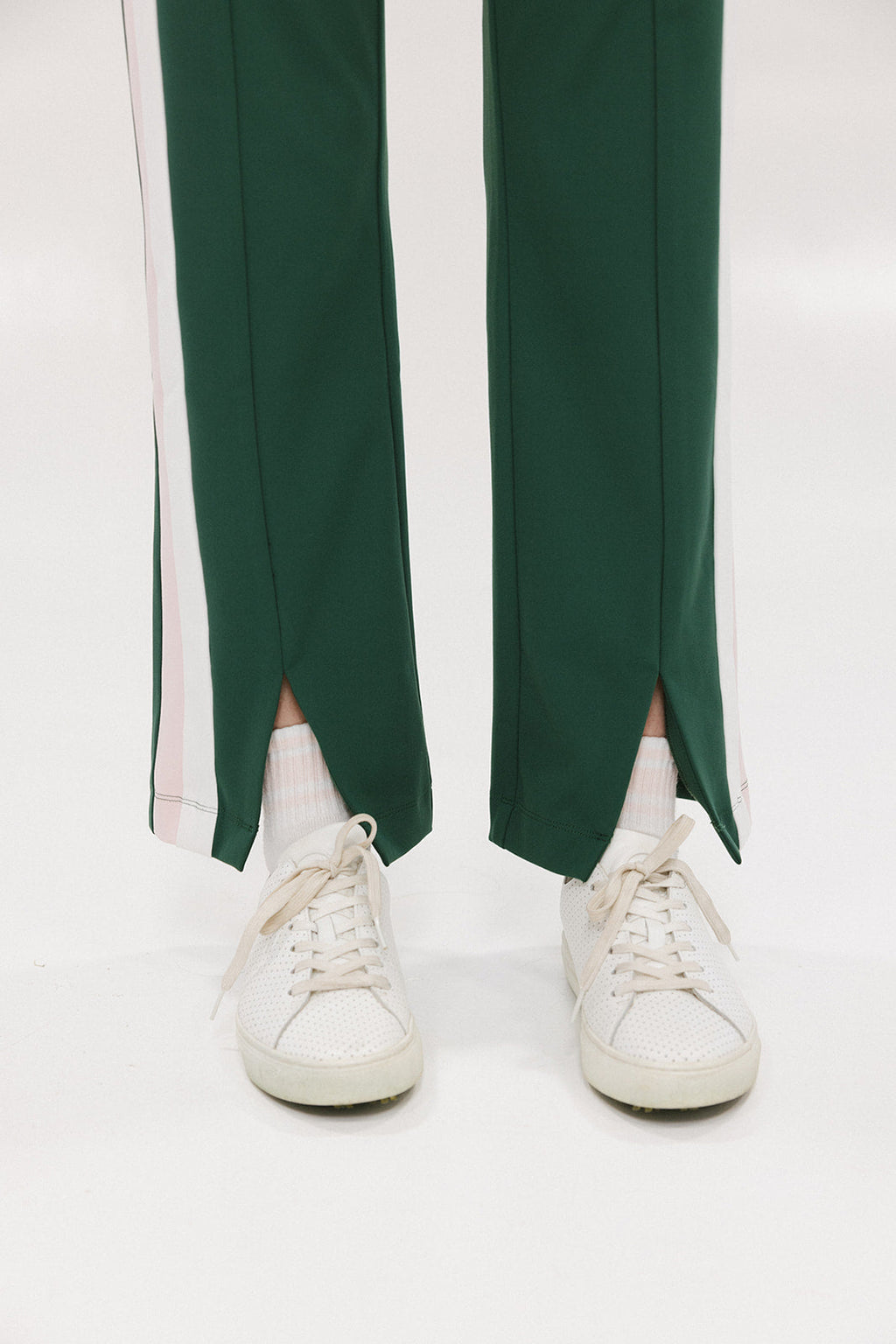 A pair of green Simone Pant with white stripes on the side, front and back pockets, and a zipper fly with snap closure.