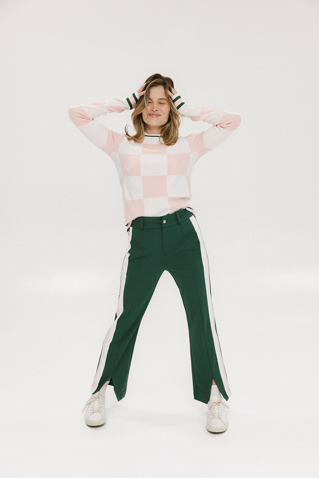 A pair of green Simone Pant with white stripes on the side, front and back pockets, and a zipper fly with snap closure.