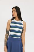 A woman wearing a sleeveless tank top with a striped pattern in blue and white colors, paired with a solid blue skirt.